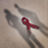 A red AIDS ribbon between two shadows of people